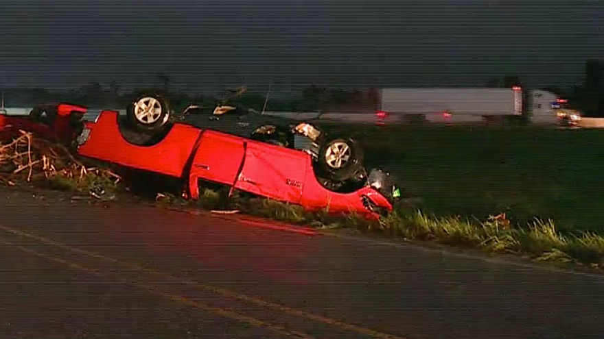 Một chiếc xe ô tô bị lốc xoáy thổi lật vào vệ đường. 