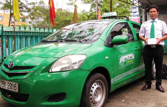 Tài xế Nguyễn Vinh Hồng Phúc và số tiền lớn nhặt được chờ trả cho khách hàng. Ảnh: Ngọc Văn 