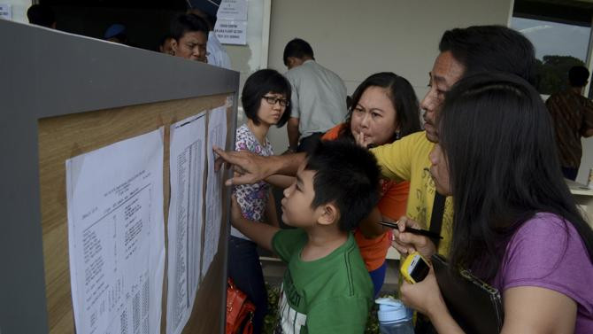 Danh sách hành khách chuyến bay QZ8501 được dán bên trong một trung tâm khẩn cấp tại sân bay Juanda ở Surabaya, Indonesia.