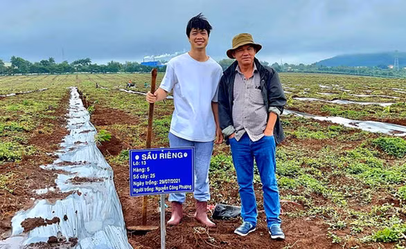 Công Phượng và bầu Đức trên khu đất trồng cây sầu riêng nông trại Hàm Rồng. (ảnh HAGL FC)