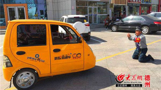 Nhân viên bảo vệ tên Fu Chongming quỳ gối trước chiếc xe điện