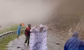 Đất đá từ trên núi rơi xuống khi đoàn cán bộ đi kiểm tra sạt lở