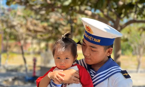 Chiến sĩ trẻ bế em bé của người dân sinh sống trên đảo Đá Tây A 