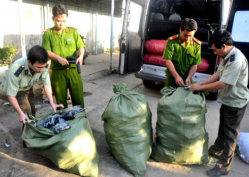 Các cơ quan chức năng kiểm tra các bao hàng chứa súng nhựa trên xe chở khách. Ảnh: VnExpress
