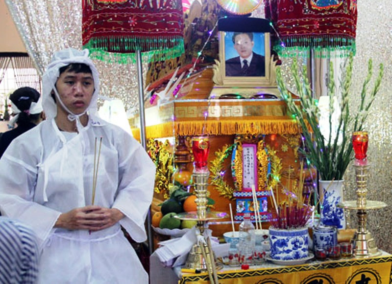 Con trai lớn của ông Chín đứng bên linh cữu cha. Ảnh: An Nhơn.