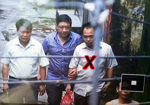 Dẫn giải Phan Thanh Bình (dấu X) ra xe - Ảnh: Nam Anh (Thanh Niên) 