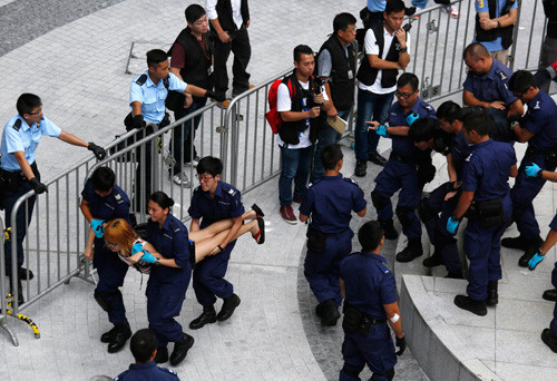  Cảnh sát Hồng Kông khiêng từng sinh viên ra khỏi trụ sở chính quyền - Ảnh: Reuters 