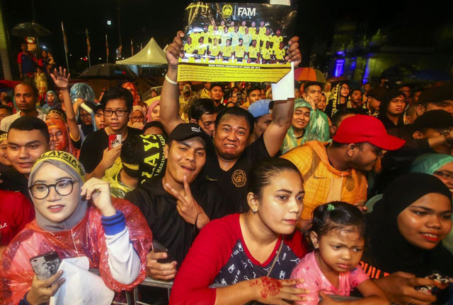 CĐV Malaysia đội mưa chờ đội nhà về nước.