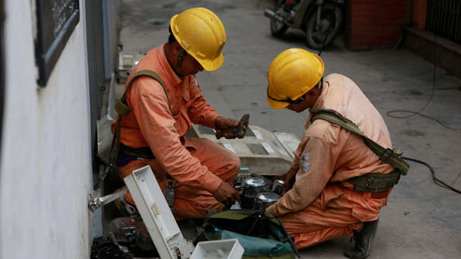Thoái vốn ngoài ngành đang là việc không dễ dàng đối với DNNN, trong đó có EVN (ảnh công nhân ngành điện đang làm việc ngoài trời). ẢNH: HỒNG VĨNH