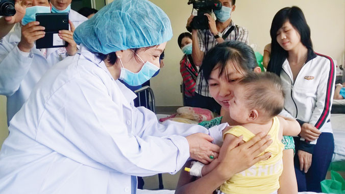 Bộ trưởng Bộ Y tế Nguyễn Thị Kim Tiến thăm và tặng quà cho bệnh nhi sởi đang điều trị ở Bệnh viện Nhi đồng 1 TPHCM. Ảnh: l.N