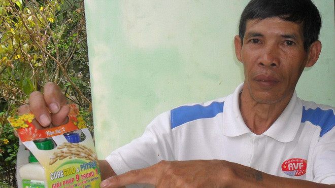 Ông Trần Văn Điền với sản phẩm gây hại lúa của Cty Lúa Vàng. ẢNH: HÒA HỘI