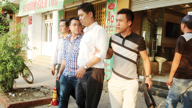 Bác sỹ Tường (áo trắng) bị dẫn giải ra cầu Thanh Trì thực nghiệm điều tra. Ảnh: Lê Dương