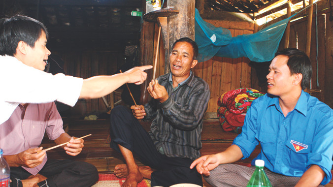 Ông Vương Chính Minh (giữa) mô tả phong tục của người La Chí ở Bản Phùng. Ảnh: Xuân Tùng