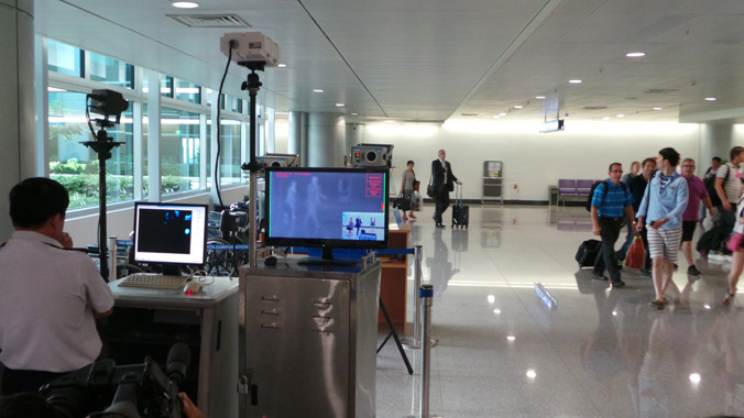 Kiểm tra hành khách bằng máy đo thân nhiệt tại sân bay Tân Sơn Nhất sáng 12/8. Ảnh: L.N