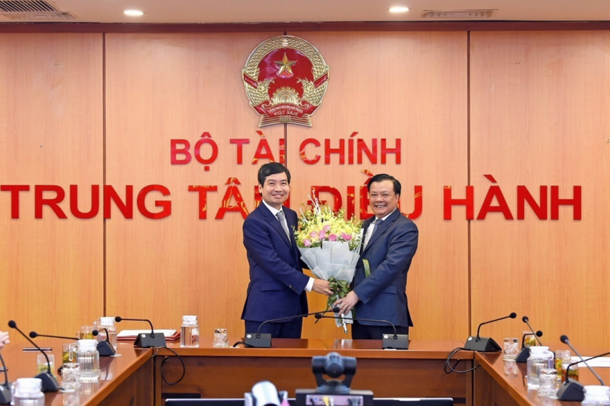 Bộ trưởng Đinh Tiến Dũng trao quyết định và chúc mừng tân Thứ trưởng Tạ Anh Tuấn. 