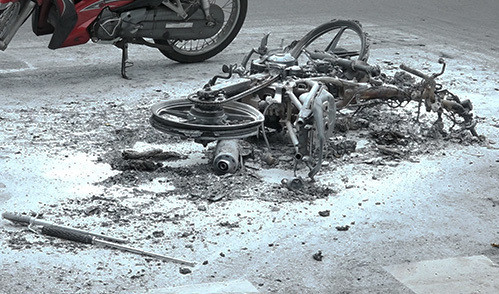 Xe của hai thanh niên cháy trơ khung trên đường. Ảnh: Quốc Thắng. 