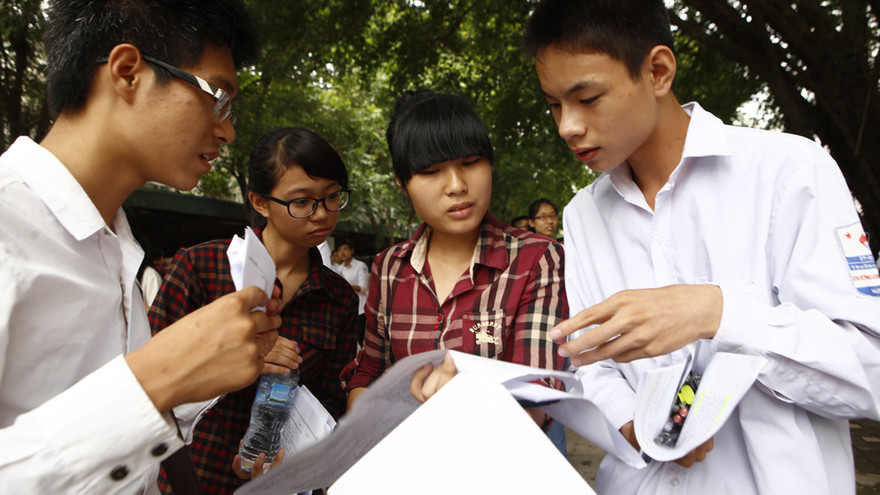 Thí sinh xem lại đề thi sau giờ làm bài môn Hóa học sáng 5/7. Ảnh: Như Ý