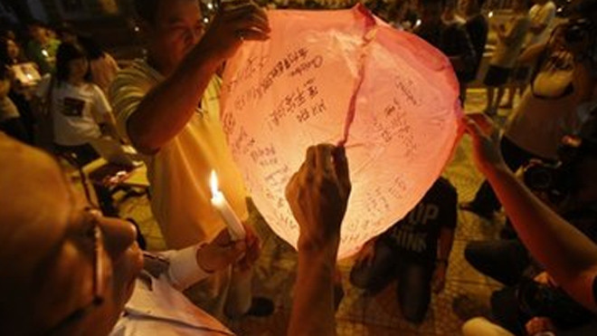 Cầu nguyện cho những người thân trên máy bay mất tích bình an. Ảnh: BBC 