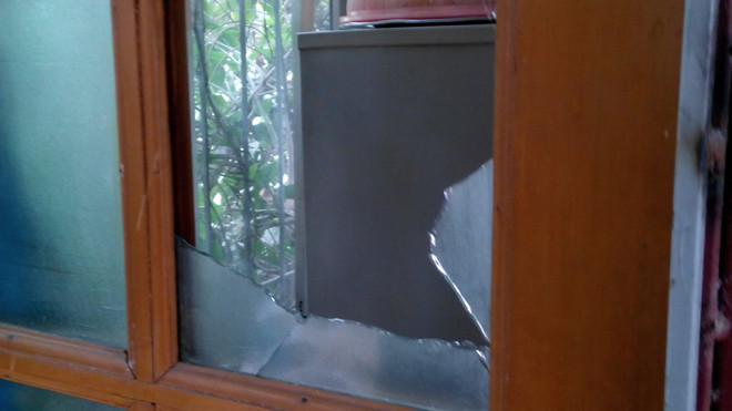 Đối tượng M chém vở ô cửa kính nhà chị Nam. Ảnh Minh Đức