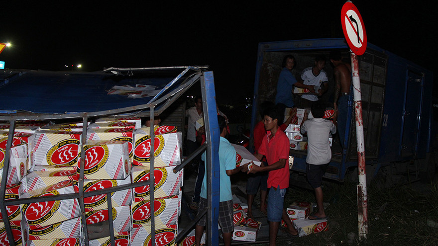 Người dân giúp tài xế nhặt lại bia. Ảnh: Đông Sơn.