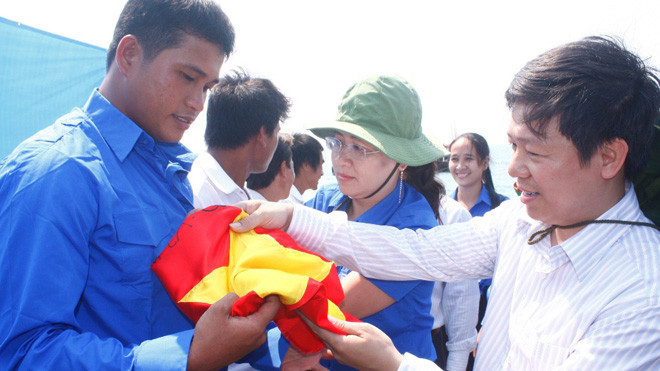 Anh Trần Thanh Lâm, Phó tổng biên tập báo Tiền Phong trao cờ cho anh Phải. ảnh: PV