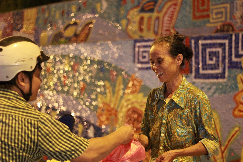 Tặng những suất ăn miễn phí cho người nghèo. Ảnh: Ngọc Tân