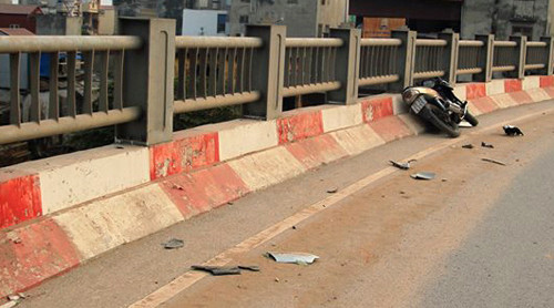 Chiếc xe máy biến dạng sau cú va chạm vào thành cầu. Nhiều mảnh vỡ bắn tung tóe. Ảnh: Phương Sơn (VnExpress)