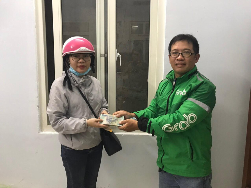 Anh Huy (bên phải) trao lại số tiền 100 triệu đồng cho người đánh rơi. Ảnh người dân cung cấp.