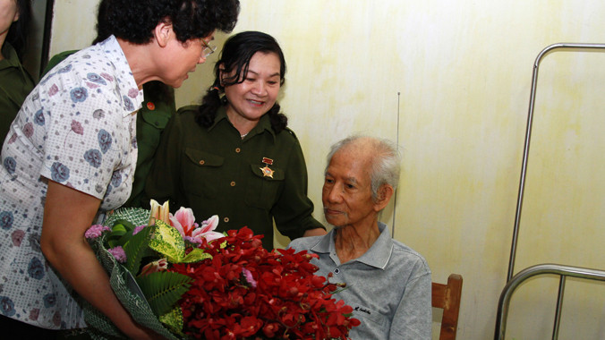 Các cựu nữ TNXP và thành viên chương trình “Hát mãi ca khúc bài ca cô gái mở đường” tặng hoa nhạc sĩ Xuân Giao. Ảnh: Mai Xuân Tùng