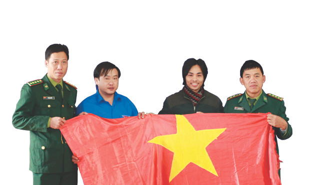 Lá cờ đỏ sao vàng từ Trường Sa được trao cho cán bộ, chiến sĩ Đồn biên phòng A Pa Chải. Ảnh: Xuân Tùng