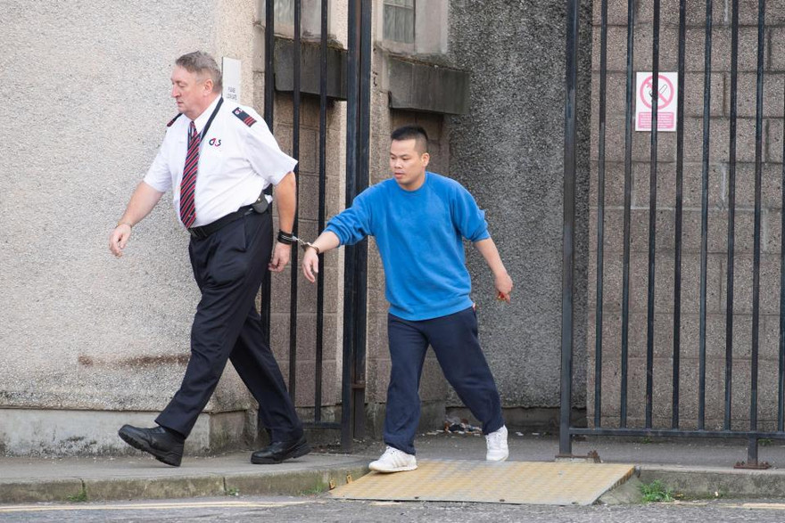 đối tượng Lê Trung Dũng đang bị cảnh sát áp tải (Ảnh: The Scottish Sun)