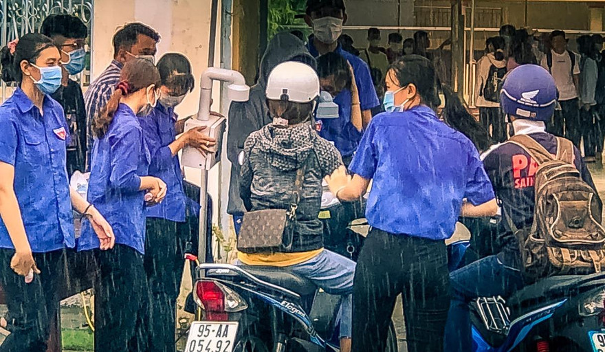 Cảm động tình nguyện viên dầm mưa hỗ trợ thí sinh thi tốt nghiệp THPT
