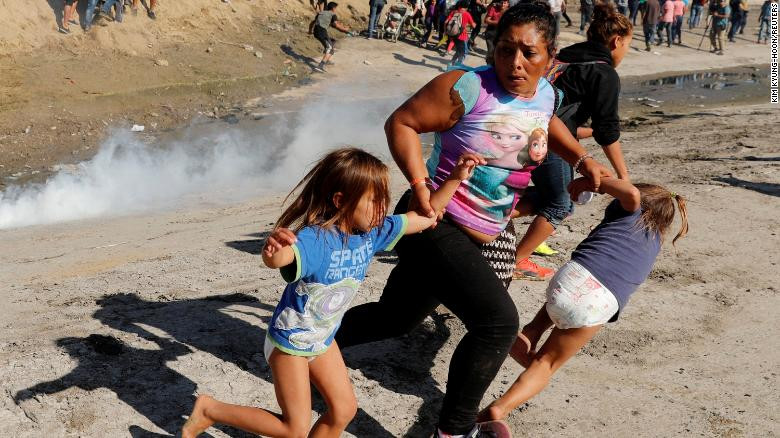 Một gia đình người di cư chạy trốn trong hoảng loạn bởi hơi cay mù mịt