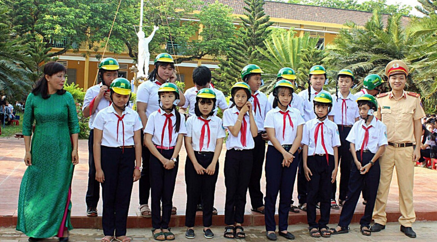 Trao mũ bảo hiểm đạt chuẩn cho các em học sinh giải đáp đúng về an toàn giao thông với trò chơi đố vui “Trả lời đúng, trúng quà”