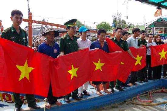 BĐBP Bạc Liêu tặng cờ Tổ quốc cho ngư dân. Ảnh: Lương Tú