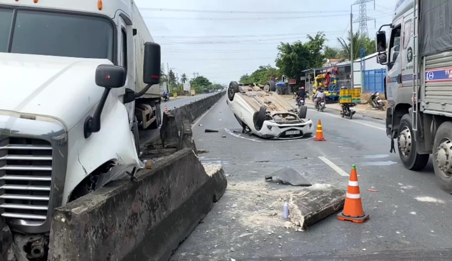 Ô tô 4 chỗ lật ngửa trên Quốc lộ 1 sau va chạm với xe đầu kéo