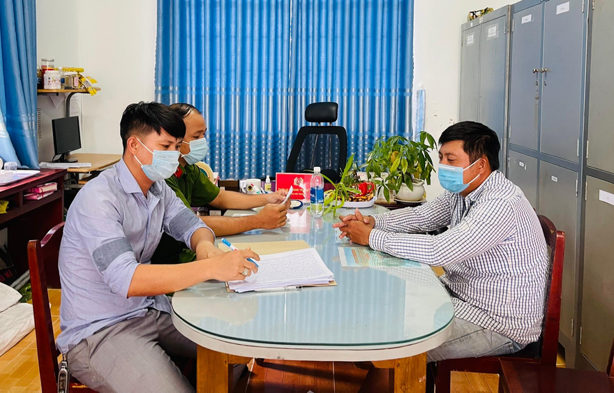 Đinh Văn Còn (bìa phải) tại cơ quan công an.