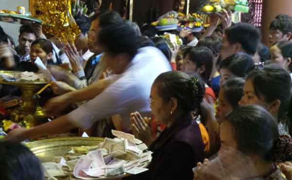 Tranh nhau đặt tiền lễ ở Chùa Hương