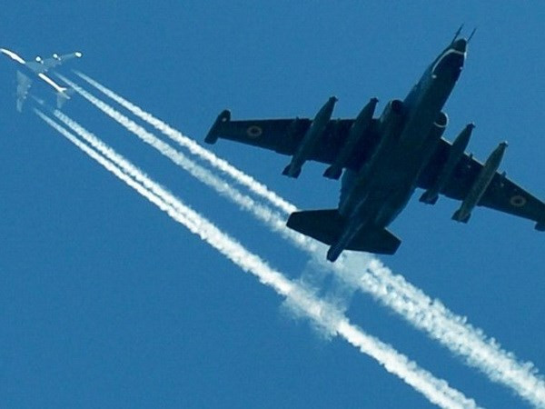 Máy bay SU-25 của Không quân Ukraine bay dưới một chiếc máy bay chở khách tại một cuộc diễn tập quân sự. (Nguồn: AFP) 