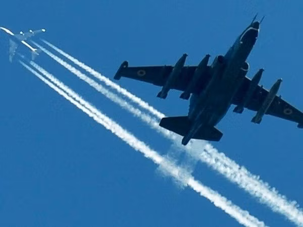 Máy bay SU-25 của Không quân Ukraine bay dưới một chiếc máy bay chở khách tại một cuộc diễn tập quân sự. (Nguồn: AFP) 