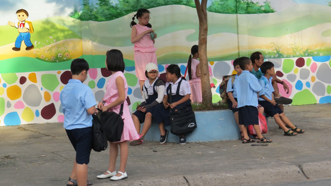 Học sinh chờ phụ huynh đến đón về. Ảnh: N.D