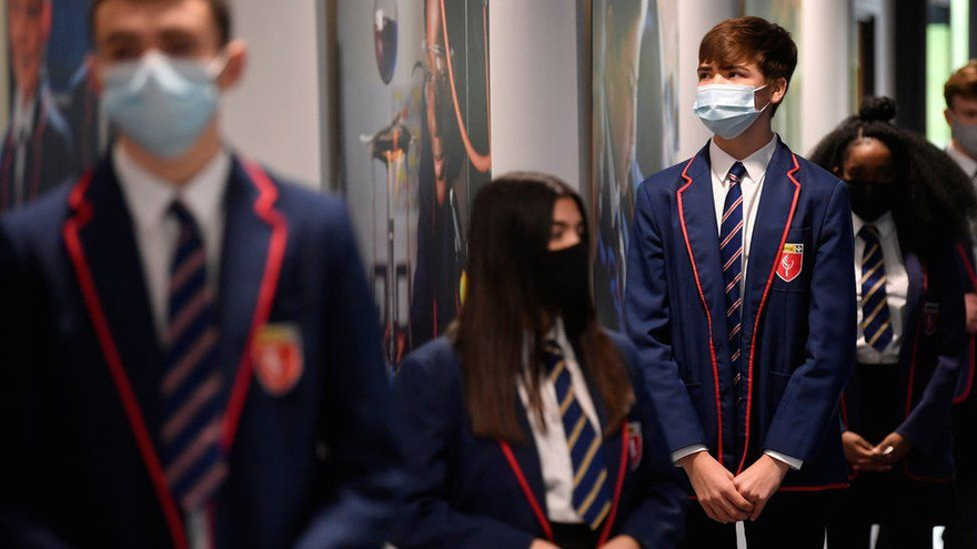 Các học sinh xếp hàng đợi xét nghiệm COVID-19 trong ngày đi học trở lại. Ảnh: Reuters.