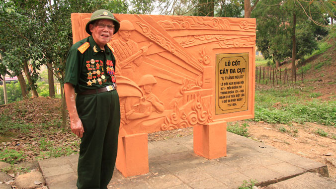 Ông Trần Quý bên di tích lô cốt Cây đa cụt. Ông chính là nguyên mẫu nhân vật ôm bộc phá trên bức phù điêu. Anh: Như Ý