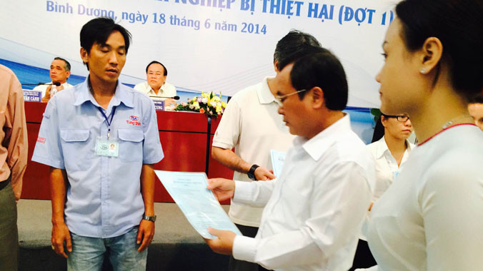 Lãnh đạo tỉnh Bình Dương trao quyết định hỗ trợ cho doanh nghiệp bị thiệt hại đợt 1. ảnh: L.N