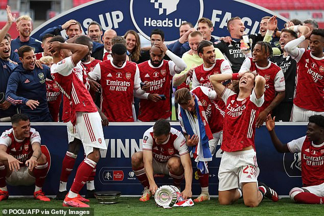 Các cầu thủ Arsenal giả vờ hoảng hốt khi Aubameyang làm rơi cúp. 