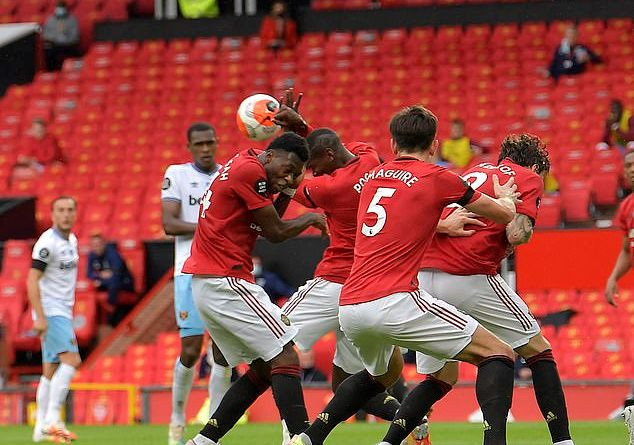 Paul Pogba dùng cả 2 tay để cản bóng, che mặt.