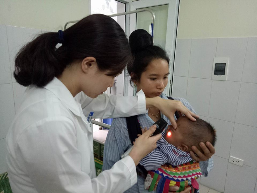 Bác sĩ Vũ Quế Anh đang xem xét tình trạng hoại tử của bé Kiên trước khi phẫu thuật cắt bỏ hoàn toàn. Ảnh: Đinh Tuấn.