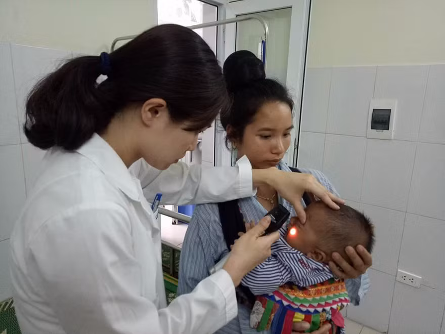 Bác sĩ Vũ Quế Anh đang xem xét tình trạng hoại tử của bé Kiên trước khi phẫu thuật cắt bỏ hoàn toàn. Ảnh: Đinh Tuấn.
