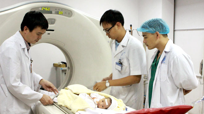  Bác sĩ bơm thuốc cản quang trước khi chụp CT 64 dãy cho cặp song sinh