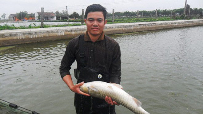 Anh Nguyễn Trọng Chiến bên mô hình trang trại kinh tế của mình